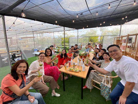 Coworkers raising their glasses at a garden party corporate bonding event at City Sprouts.