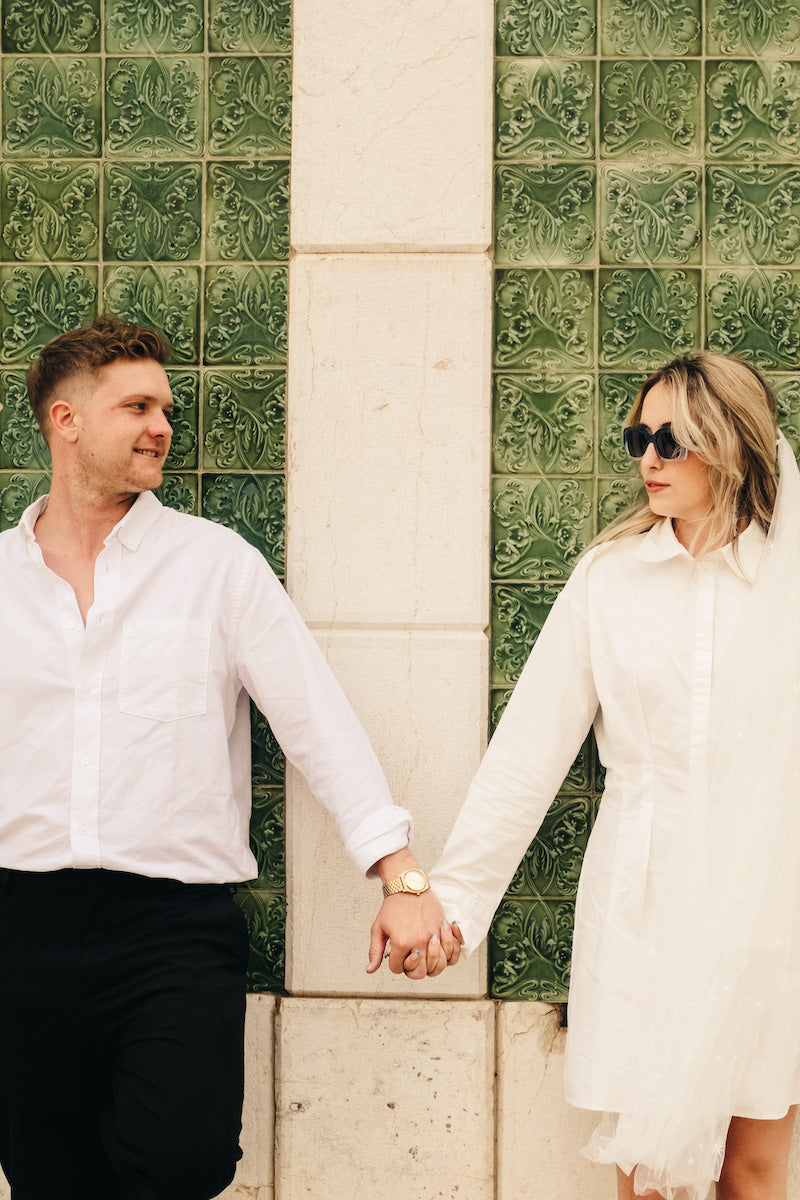 Bride and Groom stand in front of Portuguese green tiles