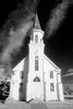 vertical black and white photo of facade of small old church