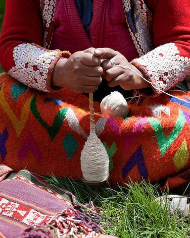 mujer indígena hilando lana