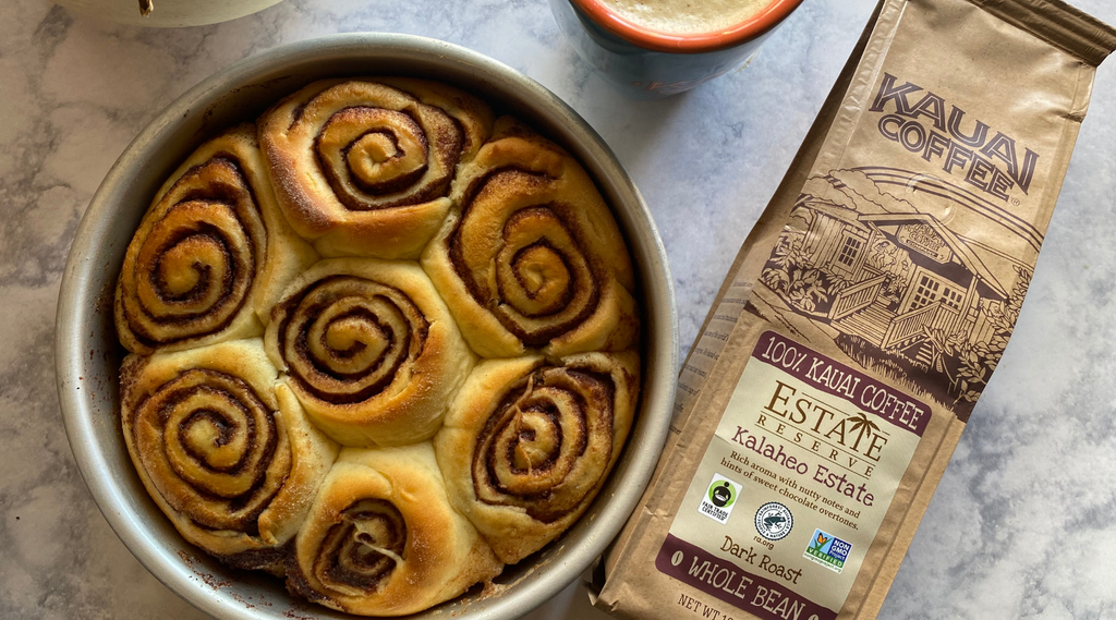 a bag of kauai coffee estate reserve kalaheo estate sits next to a round baking dish full of baked irish cream rolls