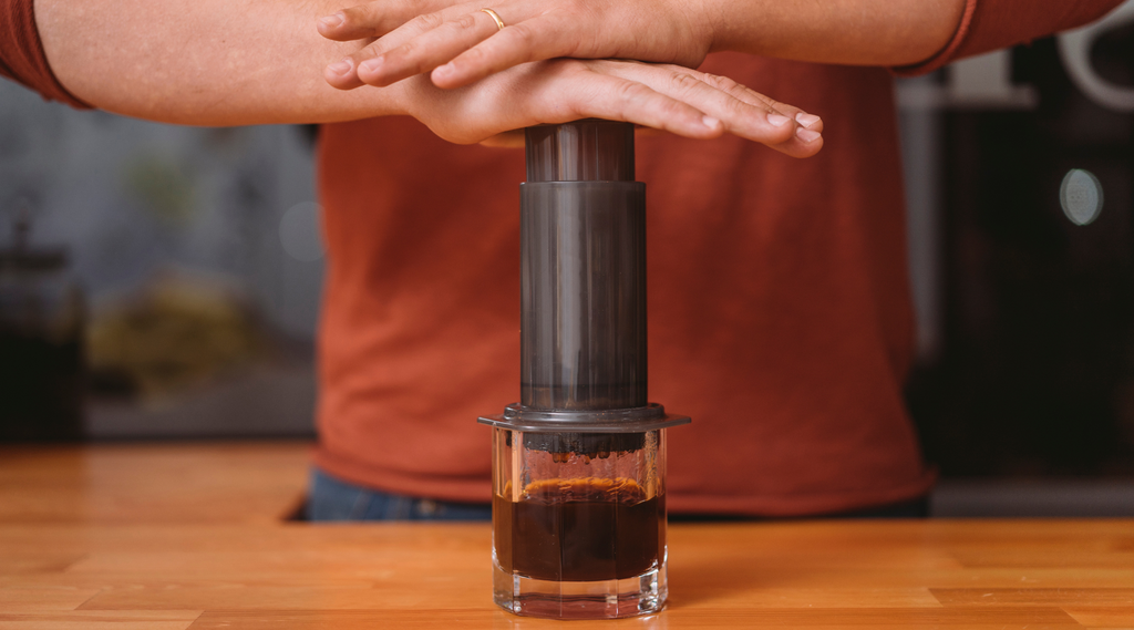 a man pressing an aeropress into a mug