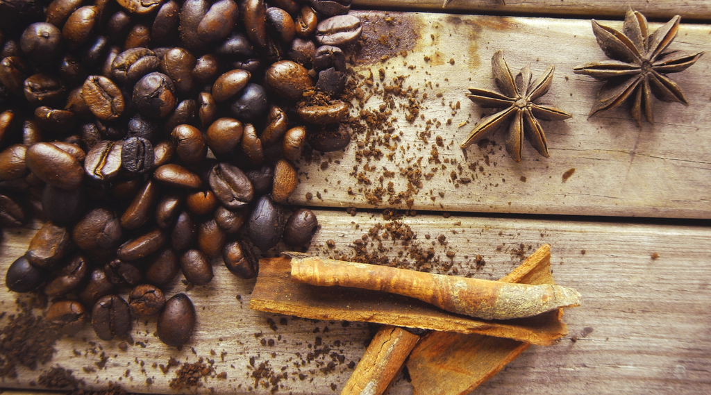 coffee beans and dried spices on a wooden surface