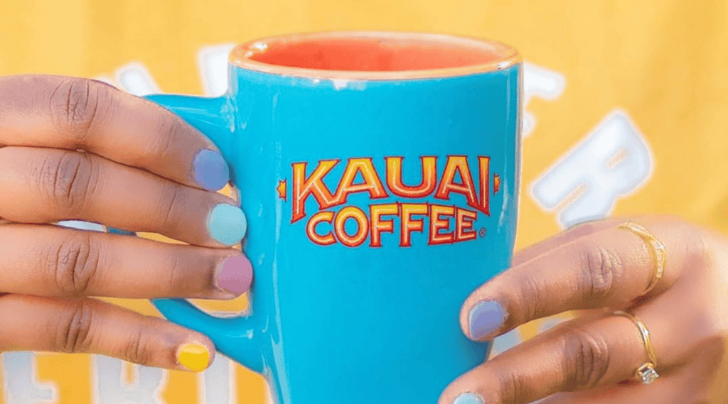 find your kauai coffee flavor match using the kauai coffee quiz. A woman holds a blue coffee mug against her bright yellow sweater