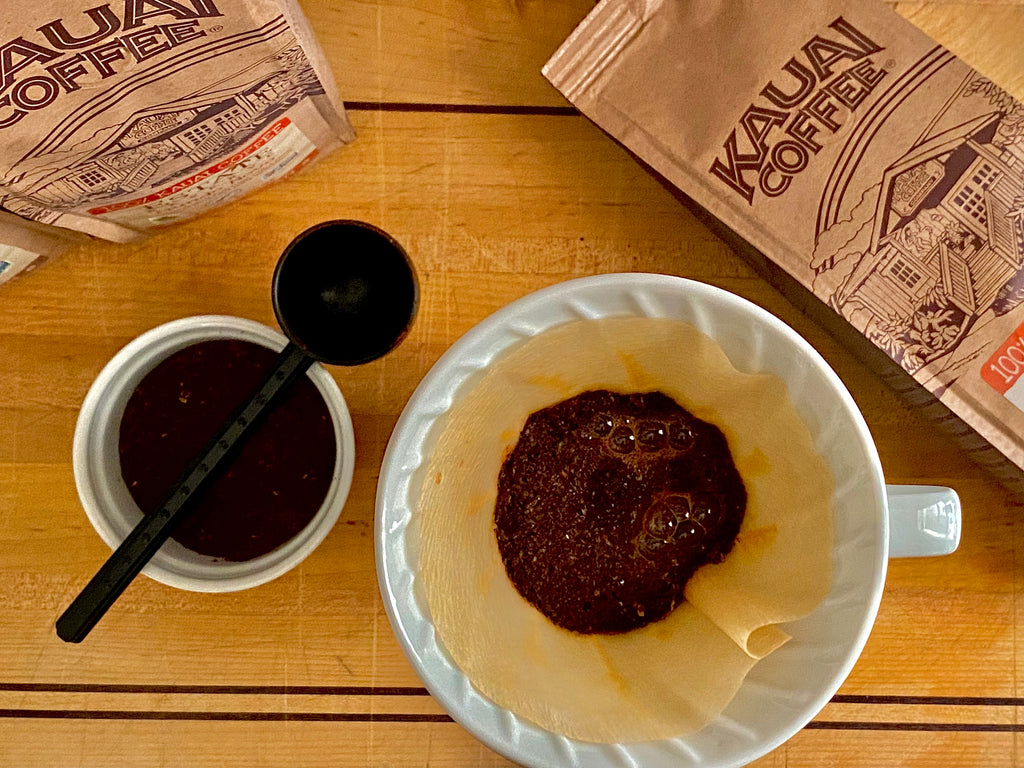 kauai coffee in a pour over brewer. The grounds have been wet and the coffee is blooming