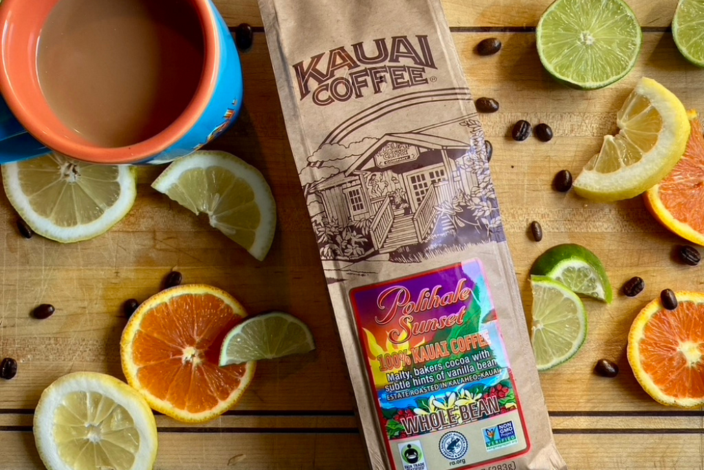kauai coffee polihale sunset lays on a wooden surface surrounded by slices of citrus fruit