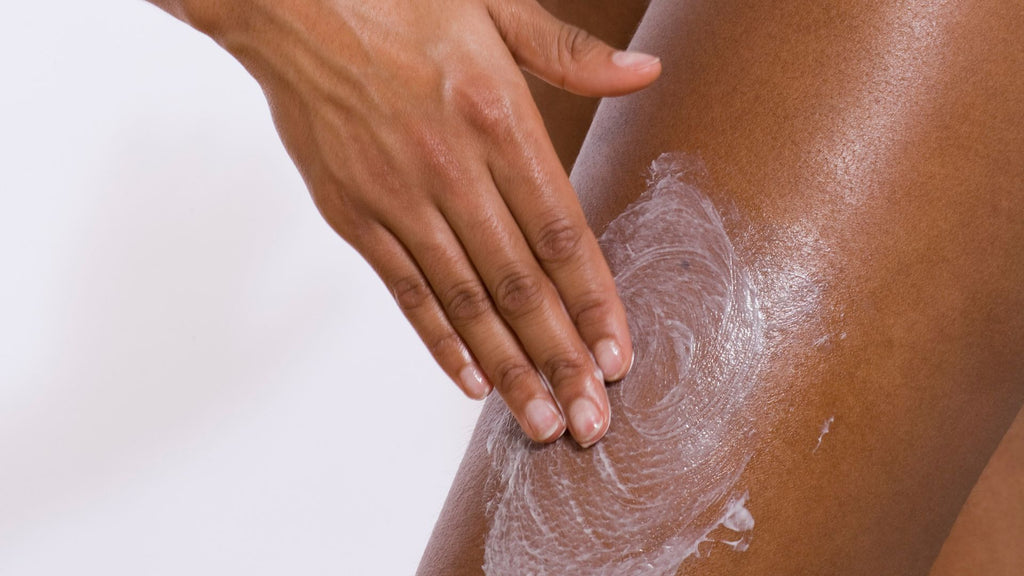 Woman massaging lotion into her leg