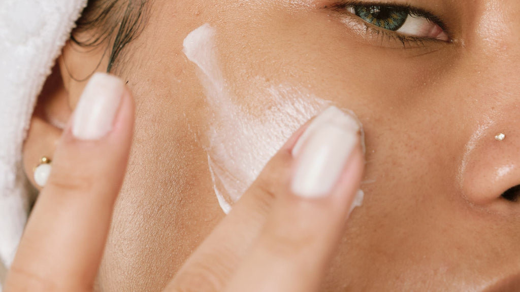 woman spreading cream product onto her face