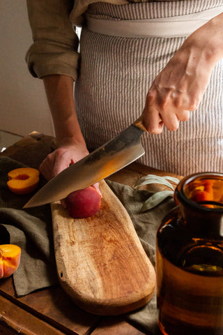Person cutting peach with a knife
