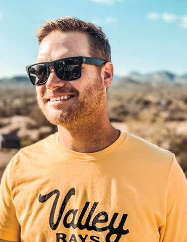 good looking man smiling wearing Valley Rays sunglasses with matte black nylon frames and black lens