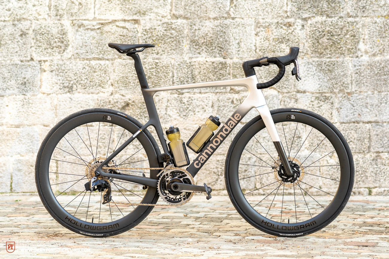 A modern road bicycle with a sleek design against a stone wall.