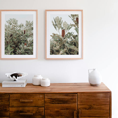 Native coastal banksia wall art prints above a rustic wooden buffet styled with white decor