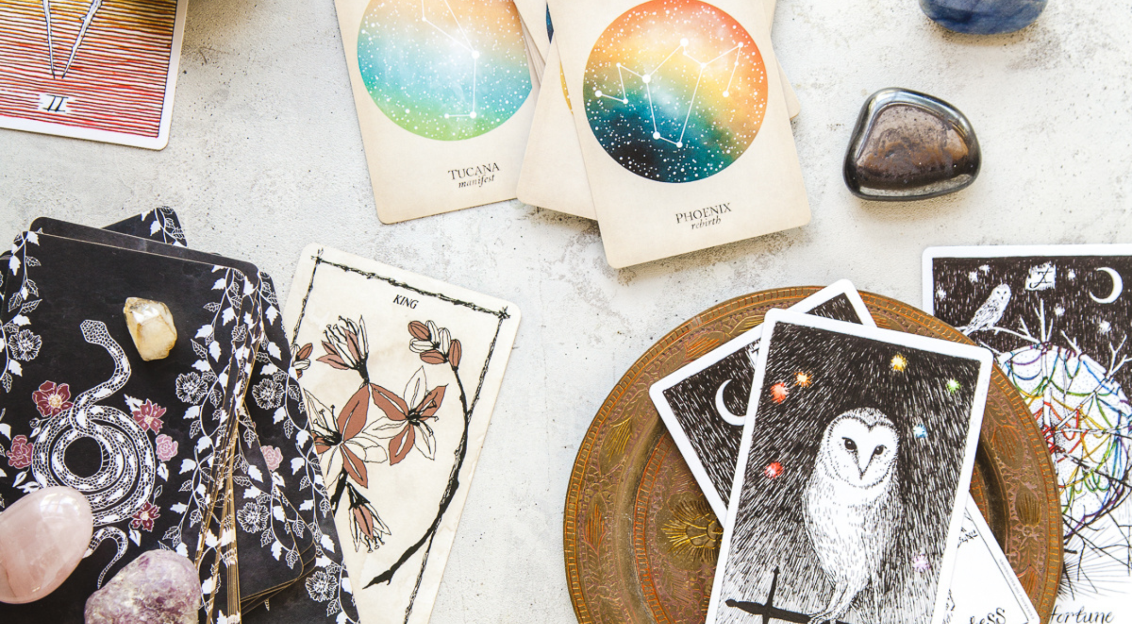 Tarot cards and crystals lay flat on a table.