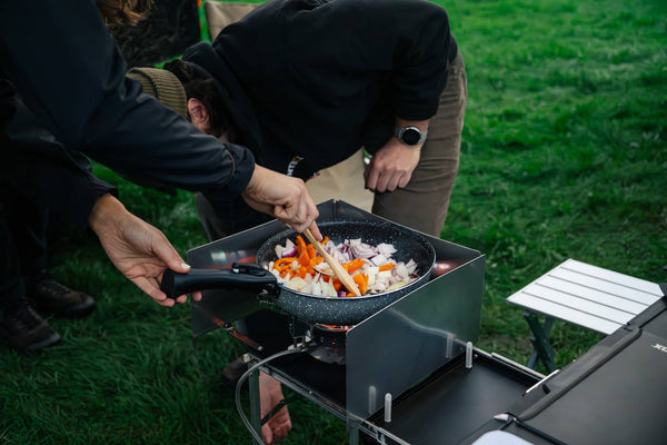 A person frying peppers and onions on their KitchenBox