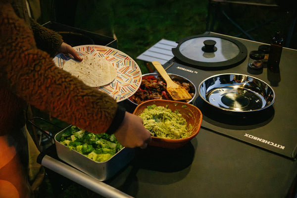 A child picking up guacamole from the KitchenBox for their taco wrap