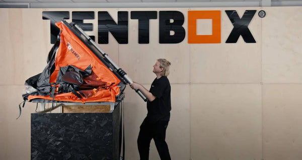 Person demonstrating how to open a TentBox Lite 1.0 roof tent