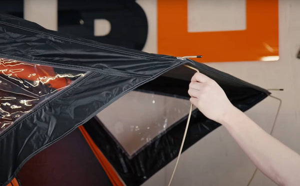 Person demonstrating how to install and use the porch poles on a TentBox Lite roof tent