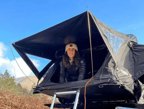 Woman inside TentBox Lite roof tent, enjoying the view