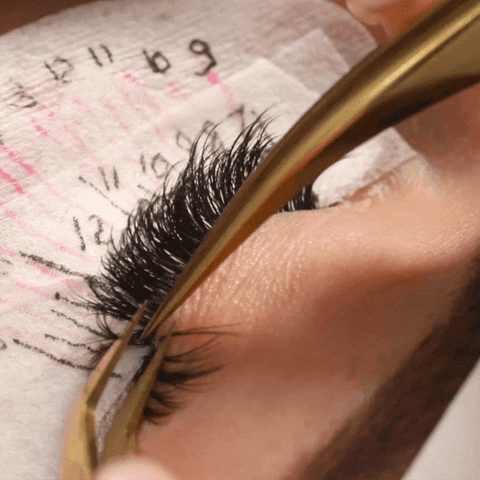 a lash tech checking for stickies and then separating one that's found