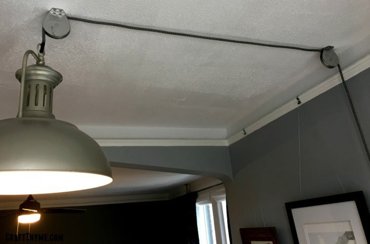 small pulleys facilitate effortless adjustment of pendant light cord lengths while adding a distinctive flair