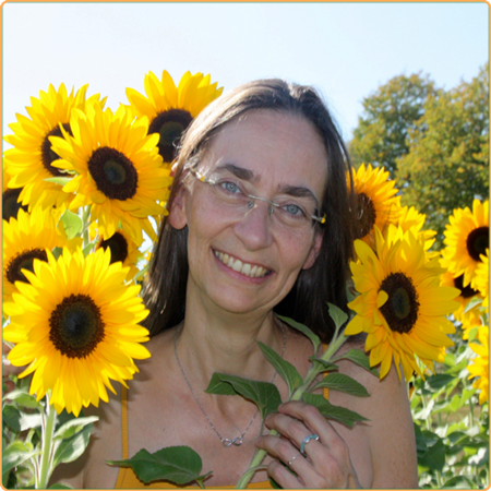 Frau mit langen Haaren und Brille in einem Sonnenblumen-Meer 