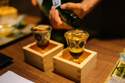 グラスに日本酒を注ぐ居酒屋の店員
