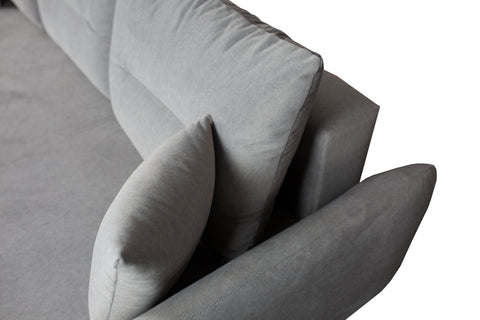 Zdjęcie przedstawiające detale podłokietnika, oparcia oraz poduszek w skandynawskiej kanapie rozkładanej z funkcją spania.