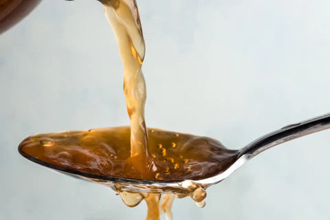 Apple cider vinegar being poured on a spoon