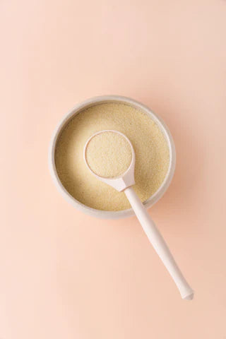 Spoonful of protein powder with a pink background
