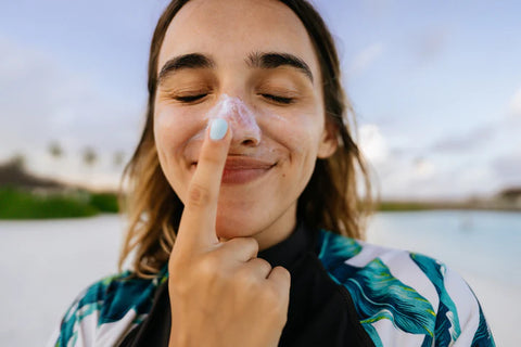 Woman putting sunscreen on her nose