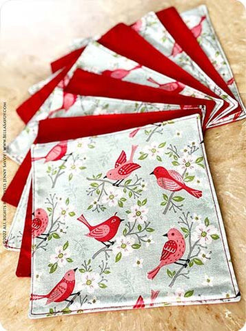 square napkins with red birds with flower branches on the front and a red back