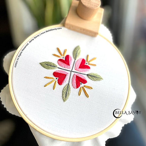 Flower Embroidery with 4 heart flowers in red and pink with yellow flowers on top. A leaf & stem between each heart.