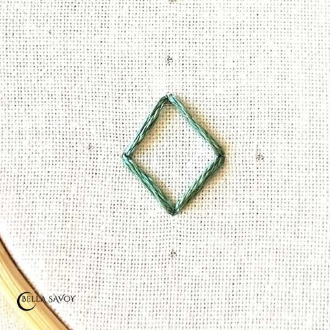 stitched diamond shape with a dot a small distance away from each point