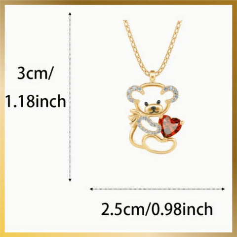 A cutest little bear with crystal stones ears and arm holding a red heart stone gold plated necklace