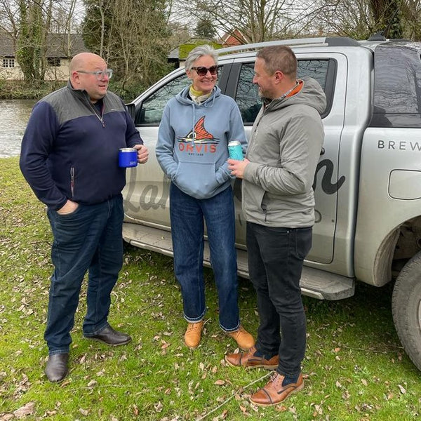 James from Lakedown Brewing Co, Claire Zambuni and Aaron Rawling, General Manager of Orvis UK share a beer on the banks of the Test