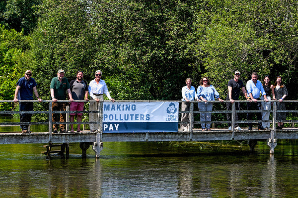Speakers at the UK River Summit lined up on a bridge over the River Test 