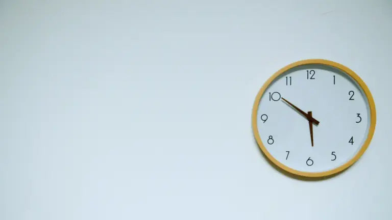 Minimalist wall clock showing 10:10 against a white background, symbolizing the timeline and onset of NMN supplement effects.