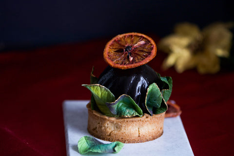 Image of individual dessert with dehydrated fruit decoration and edible sugar leaves.