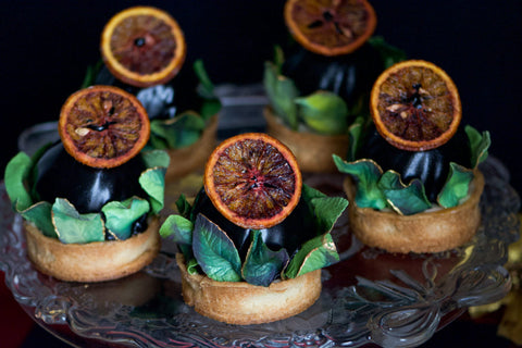Image of individual desserts with dehydrated fruit decorations and edible sugar leaves.