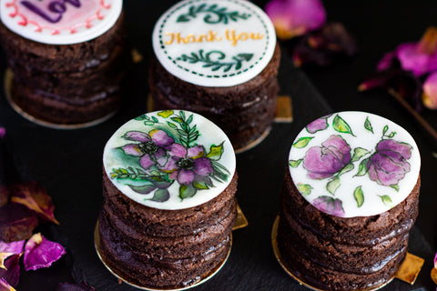 Image of chocolate individual mini cakes with edible, hand-painted decorations.