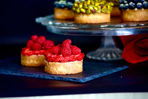 Image of individual tarts topped with sliced strawberries and fresh raspberries.