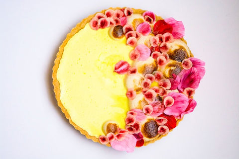 Round lemon tart decorated with cascade of edible sugar flowers