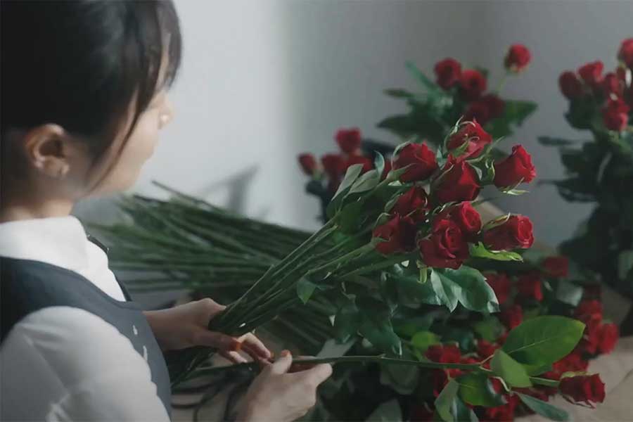 プロポーズ用にバラの花を束ねている花屋の店員