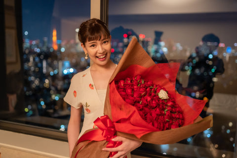 プロポーズでバラの花束を受け取り喜ぶ女性