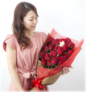 プロポーズの定番の赤い薔薇の花束を抱えた女性