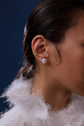 Woman wearing pearl stud earrings