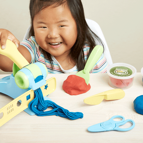 Girl crafting with Green Toys play dough tools