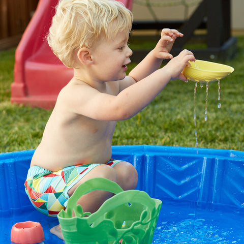 Boy playing with Tide Pool Set in paddling pool