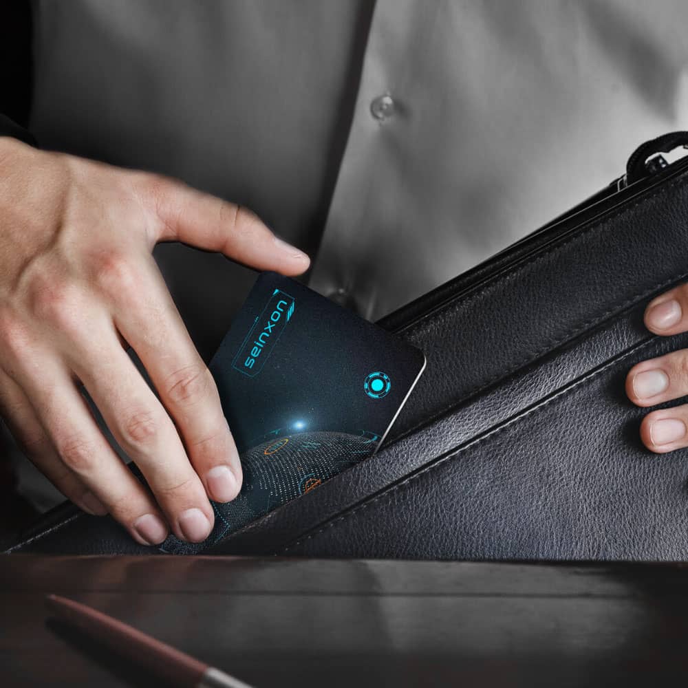 A-hand-retrieving-a-Seinxon-card-tracker-with-a-blue-light-indicator-from-a-black-leather-wallet-showcasing-the-slim-design-perfect-for-everyday-carry