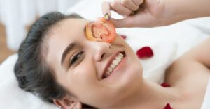 woman rubbing tomato on skin